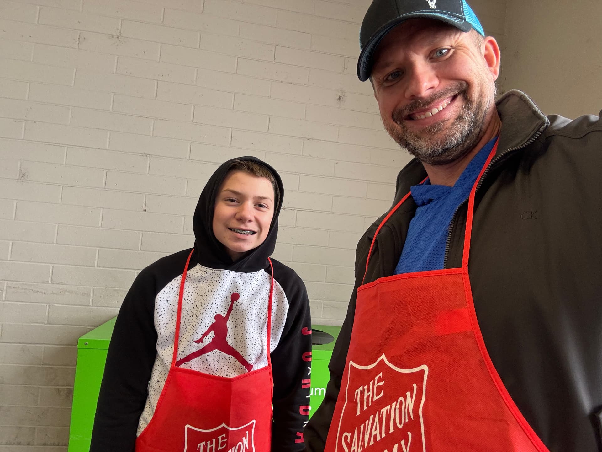 Brad and Jase wearing Salvation Army aprons while volunteering together